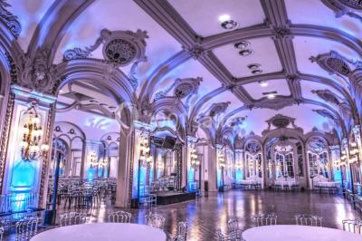 Salon avec fauteuils colorés, piano rose, bar en arrière-plan et décorations modernes dans une ambiance chaleureuse.