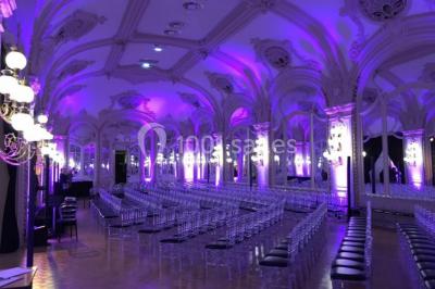 Salon avec fauteuils colorés, piano rose, bar en arrière-plan et décorations modernes dans une ambiance chaleureuse.