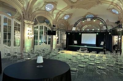 Salon avec fauteuils colorés, piano rose, bar en arrière-plan et décorations modernes dans une ambiance chaleureuse.