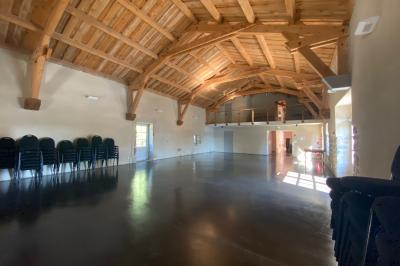 Miniature Location salle Montregard (Haute-Loire) - Château de Marcoux #4 Cour extérieure avec table et chaises en métal, entourée de murs en pierre, d'un bâtiment en pierre et d'arbres.
