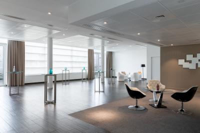 Salle de réception avec tables rondes dressées, décorées de nappes colorées et centres de table floraux.