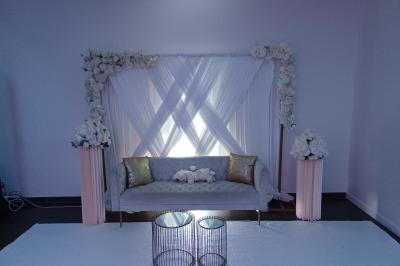 Salle de réception avec tables rondes dressées, décorées de nappes colorées et centres de table floraux.