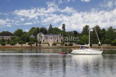 Salle de restaurant avec murs en pierre, tables en bois dressées, chaises bleues et un tableau de flamant rose au mur.
