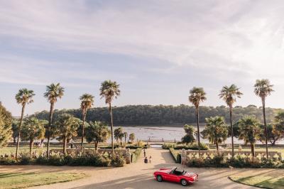 Salle de restaurant avec murs en pierre, tables en bois dressées, chaises bleues et un tableau de flamant rose au mur.