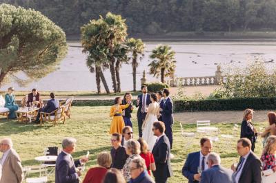 Salle de restaurant avec murs en pierre, tables en bois dressées, chaises bleues et un tableau de flamant rose au mur.