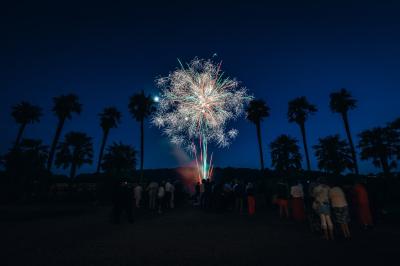 Salle de restaurant avec murs en pierre, tables en bois dressées, chaises bleues et un tableau de flamant rose au mur.