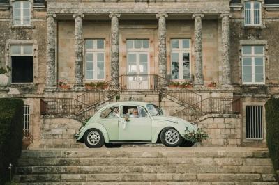 Salle de restaurant avec murs en pierre, tables en bois dressées, chaises bleues et un tableau de flamant rose au mur.