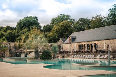 Salle de restaurant avec murs en pierre, tables en bois dressées, chaises bleues et un tableau de flamant rose au mur.