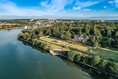Salle de restaurant avec murs en pierre, tables en bois dressées, chaises bleues et un tableau de flamant rose au mur.