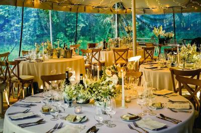 Salle de restaurant avec murs en pierre, tables en bois dressées, chaises bleues et un tableau de flamant rose au mur.