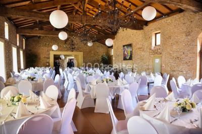 Intérieur d'une serre lumineuse avec un toit en verre, des lustres suspendus et un sol réfléchissant.