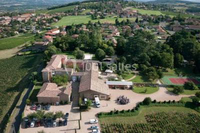 Intérieur d'une serre lumineuse avec un toit en verre, des lustres suspendus et un sol réfléchissant.