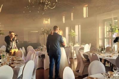 Intérieur d'une serre lumineuse avec un toit en verre, des lustres suspendus et un sol réfléchissant.