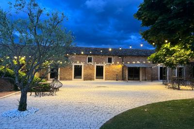 Intérieur d'une serre lumineuse avec un toit en verre, des lustres suspendus et un sol réfléchissant.