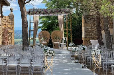 Intérieur d'une serre lumineuse avec un toit en verre, des lustres suspendus et un sol réfléchissant.
