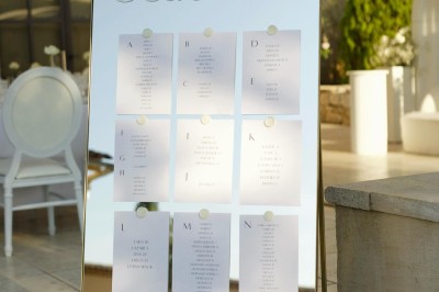 Un couple en tenue de mariage s'enlace dans un champ entouré d'oliviers sous une lumière douce.