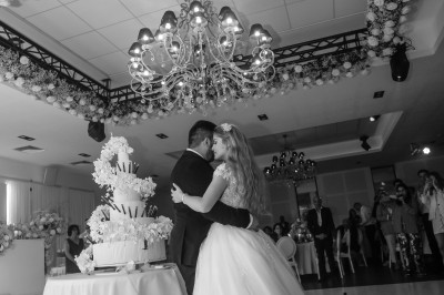 Un couple en tenue de mariage s'enlace dans un champ entouré d'oliviers sous une lumière douce.