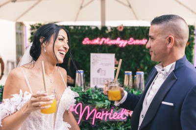 Un couple en tenue de mariage s'enlace dans un champ entouré d'oliviers sous une lumière douce.