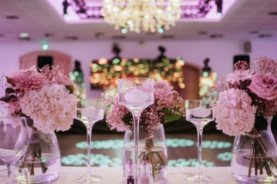 Un couple en tenue de mariage s'enlace dans un champ entouré d'oliviers sous une lumière douce.