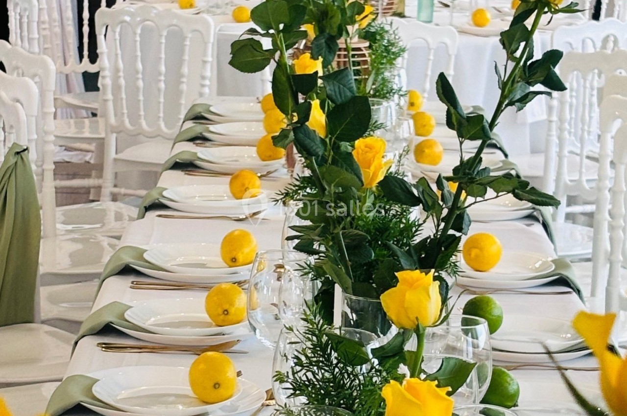 Location salle Hem (Nord) - Le Comte #5 Table décorée avec des roses jaunes, des citrons et des éléments verts, entourée de chaises blanches.