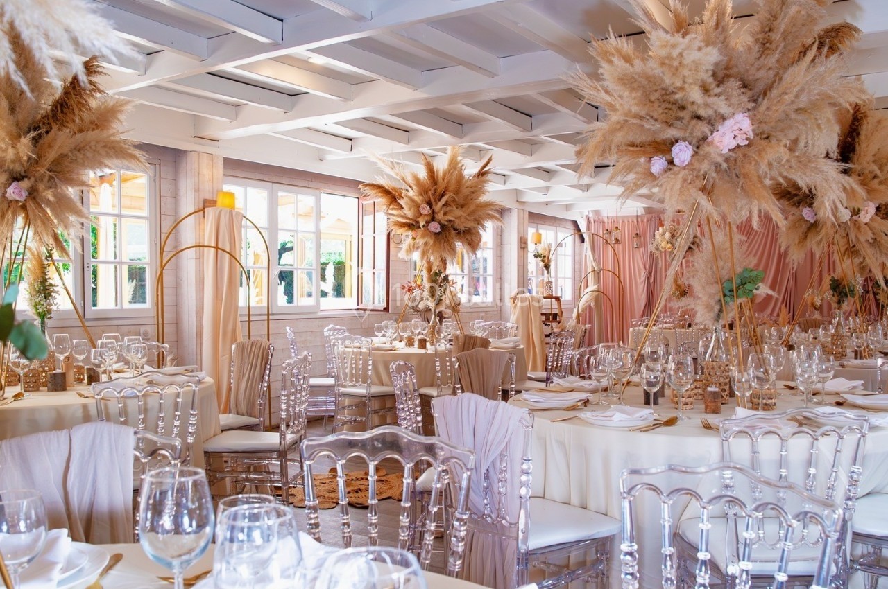 Location salle Hem (Nord) - Le Comte #22 Salle de réception décorée avec des tables élégantes, des chaises transparentes et des compositions florales séchées…