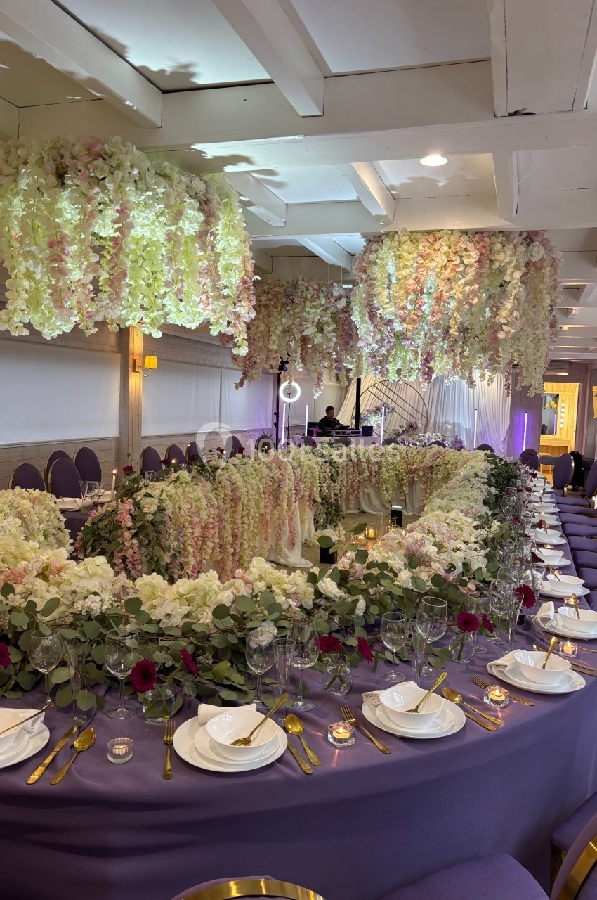 Location salle Hem (Nord) - Le Comte #27 Salle de réception décorée avec des tables violettes, des fleurs suspendues et des arrangements floraux élégants.