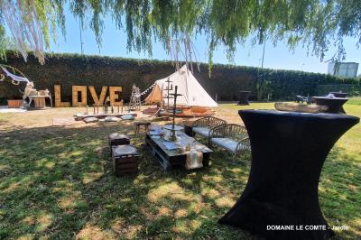 Table élégamment dressée avec vaisselle blanche et décorations florales, donnant sur une piste équestre en arrière-plan.