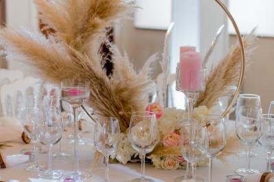 Table élégamment dressée avec vaisselle blanche et décorations florales, donnant sur une piste équestre en arrière-plan.