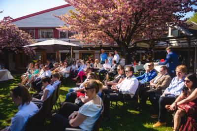 Table élégamment dressée avec vaisselle blanche et décorations florales, donnant sur une piste équestre en arrière-plan.