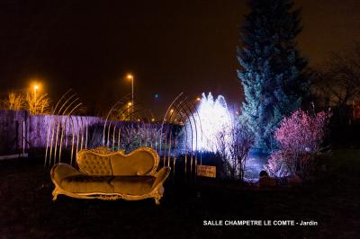 Table élégamment dressée avec vaisselle blanche et décorations florales, donnant sur une piste équestre en arrière-plan.