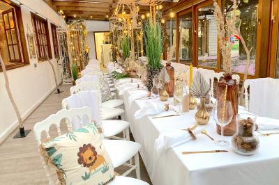 Table élégamment dressée avec vaisselle blanche et décorations florales, donnant sur une piste équestre en arrière-plan.