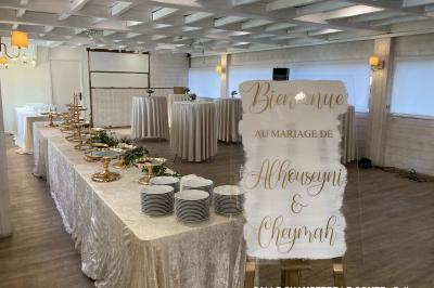 Table élégamment dressée avec vaisselle blanche et décorations florales, donnant sur une piste équestre en arrière-plan.