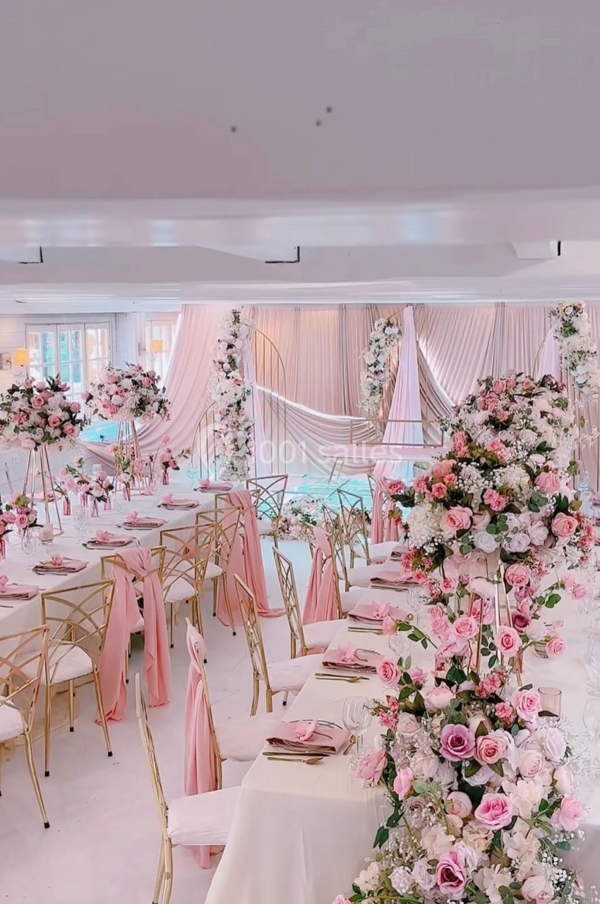 SALLE CHAMPETRE - jusque 100 pers Salle de réception décorée avec des fleurs roses et blanches, nappes et chaises assorties dans une ambiance élégante.