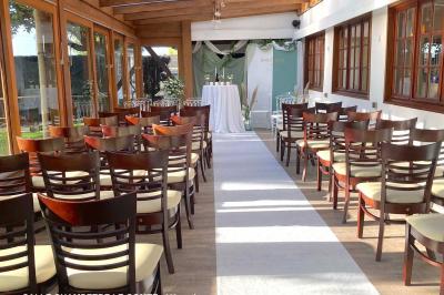 Table élégamment dressée avec vaisselle blanche et décorations florales, donnant sur une piste équestre en arrière-plan.