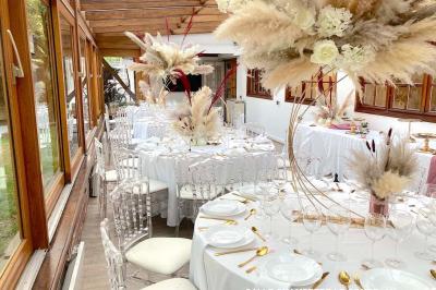 Table élégamment dressée avec vaisselle blanche et décorations florales, donnant sur une piste équestre en arrière-plan.