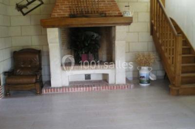 Lit double avec couvre-lit blanc, deux oreillers, table de chevet avec lampe rose et décoration florale sur les murs.