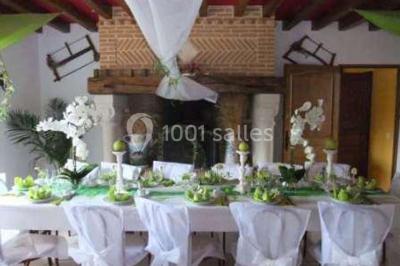 Lit double avec couvre-lit blanc, deux oreillers, table de chevet avec lampe rose et décoration florale sur les murs.