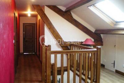 Lit double avec couvre-lit blanc, deux oreillers, table de chevet avec lampe rose et décoration florale sur les murs.