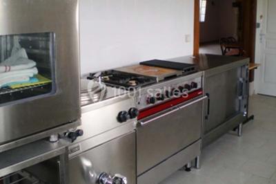 Lit double avec couvre-lit blanc, deux oreillers, table de chevet avec lampe rose et décoration florale sur les murs.