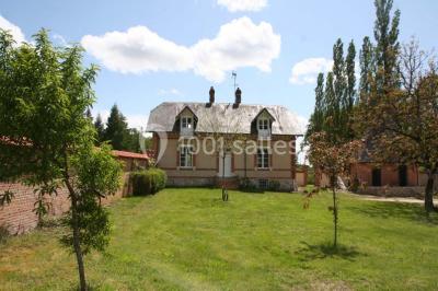 Deux canapés gris dans un salon lumineux avec une grande fenêtre, une lampe allumée et des décorations murales.
