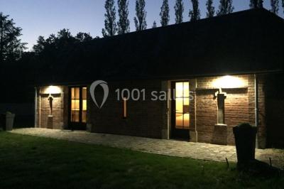 Deux canapés gris dans un salon lumineux avec une grande fenêtre, une lampe allumée et des décorations murales.