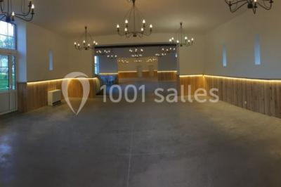 Deux canapés gris dans un salon lumineux avec une grande fenêtre, une lampe allumée et des décorations murales.