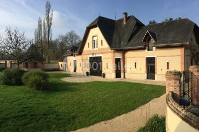 Deux canapés gris dans un salon lumineux avec une grande fenêtre, une lampe allumée et des décorations murales.