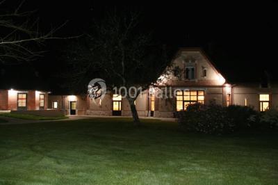 Deux canapés gris dans un salon lumineux avec une grande fenêtre, une lampe allumée et des décorations murales.