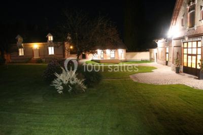 Deux canapés gris dans un salon lumineux avec une grande fenêtre, une lampe allumée et des décorations murales.