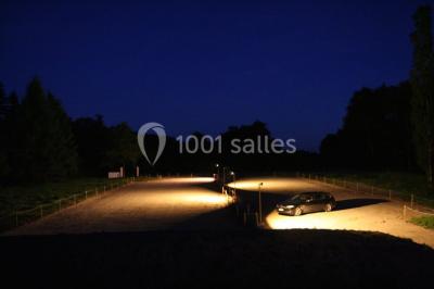 Deux canapés gris dans un salon lumineux avec une grande fenêtre, une lampe allumée et des décorations murales.