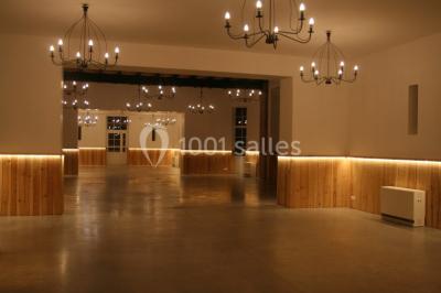 Deux canapés gris dans un salon lumineux avec une grande fenêtre, une lampe allumée et des décorations murales.