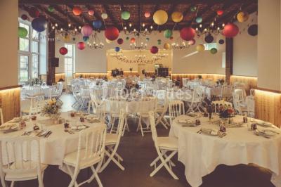 Deux canapés gris dans un salon lumineux avec une grande fenêtre, une lampe allumée et des décorations murales.