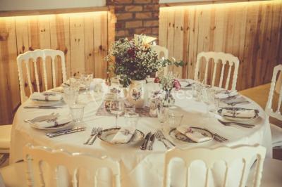 Deux canapés gris dans un salon lumineux avec une grande fenêtre, une lampe allumée et des décorations murales.