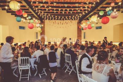 Deux canapés gris dans un salon lumineux avec une grande fenêtre, une lampe allumée et des décorations murales.